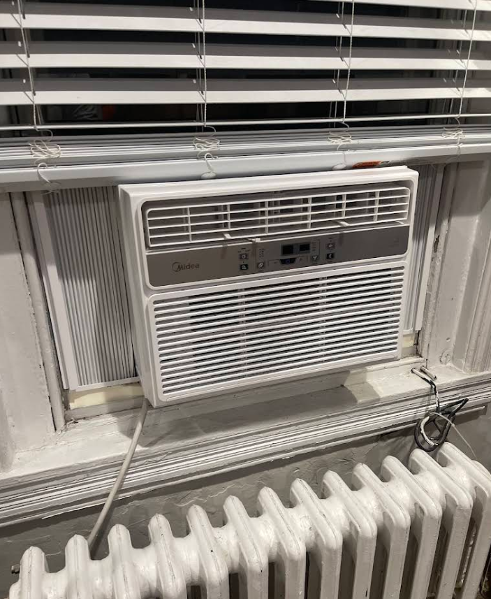 Window AC unit installed above radiator